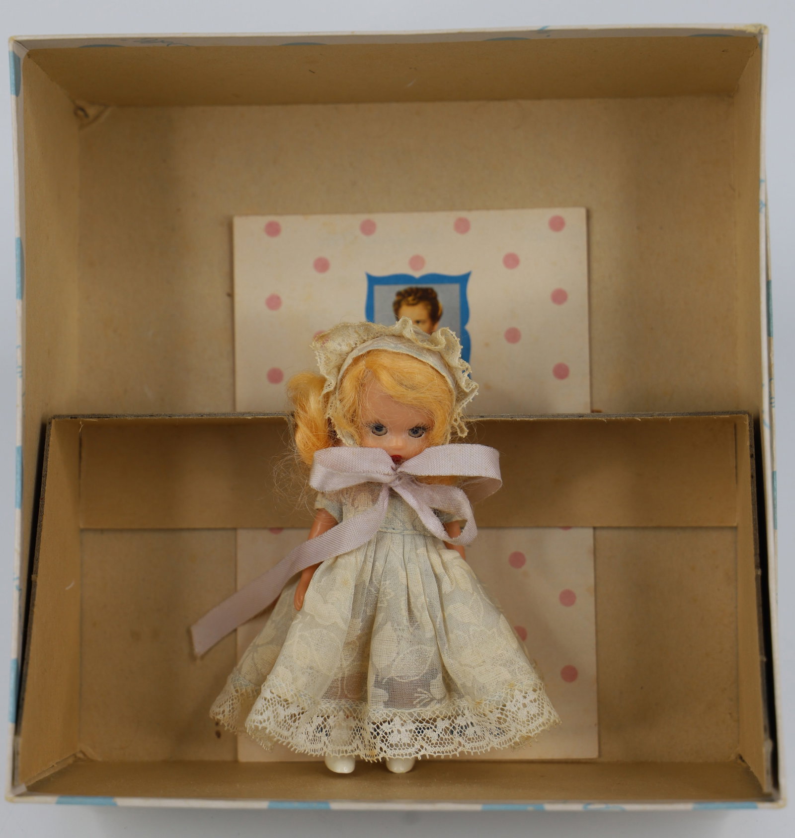 Nancy Ann Storybook Doll: Commencement series; "First Birthday"; Number 71; Plastic with open/close eyes; Measures approximately H 4 1/2 inches; Dress is discolored; No guarantee doll is in correct box. See photos