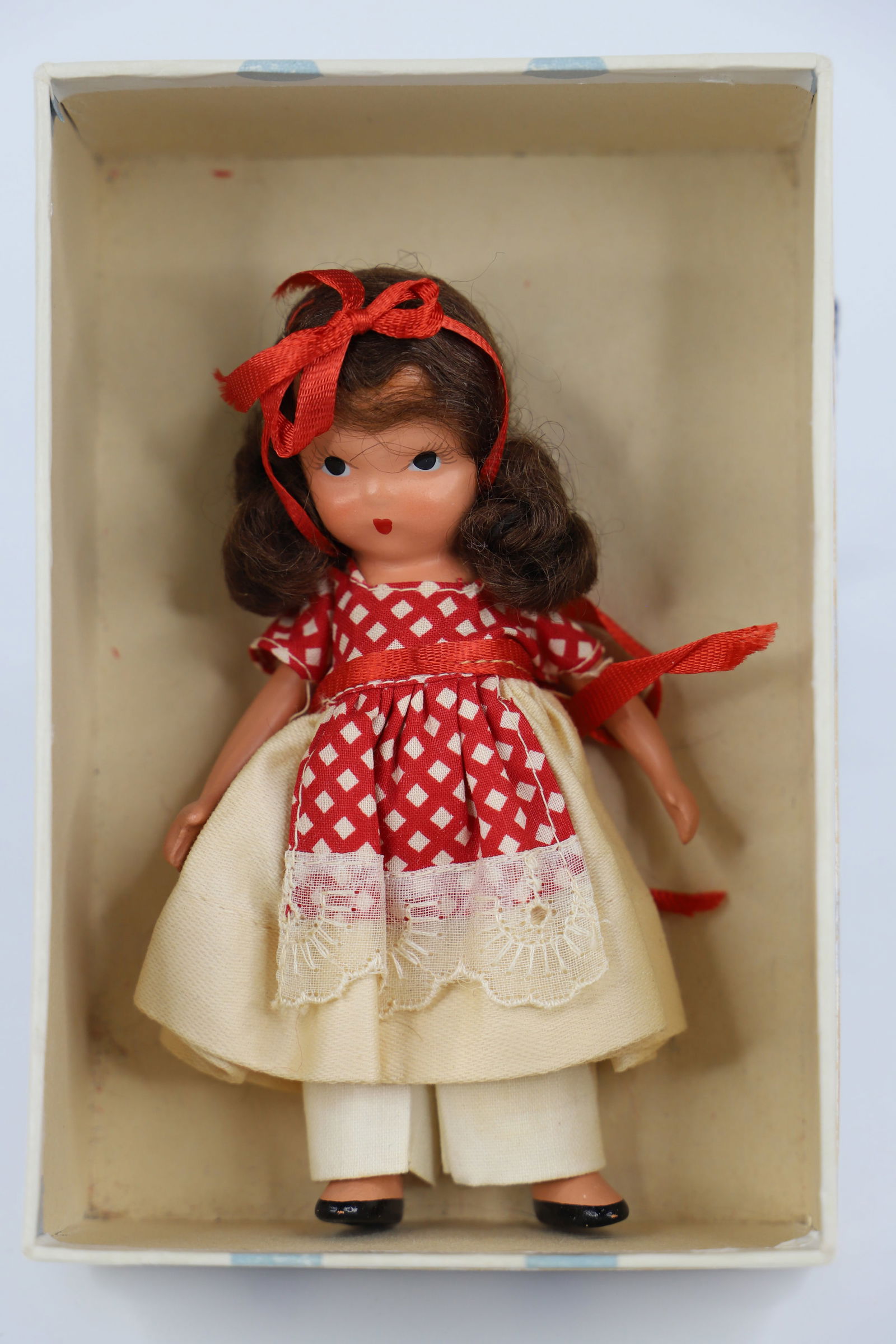 Nancy Ann Storybook Doll: "School Days, School Days, Dear Old Golden Rule Days"; Number 117; Bisque with painted face; Measures approximately H 5 inches; Clothes are stained; Box top has water damage; No guarantee doll is in c