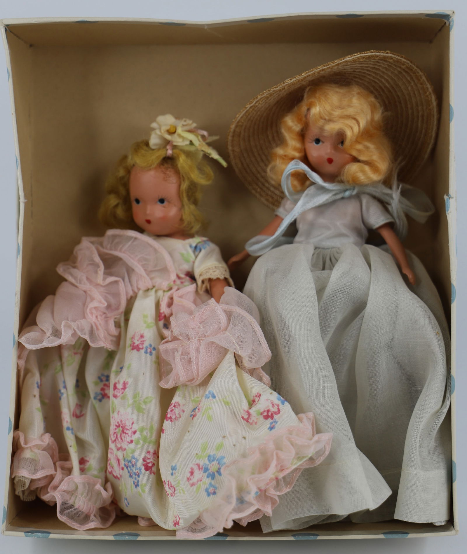 Nancy Ann Storybook Doll: Two dolls in a box marked "A Flower Girl for May"; Number 191; Bisque with painted faces; One has stiff legs; Tallest measures approximately H 6 1/4 inches; Hair is frail on small doll; Box top is tor
