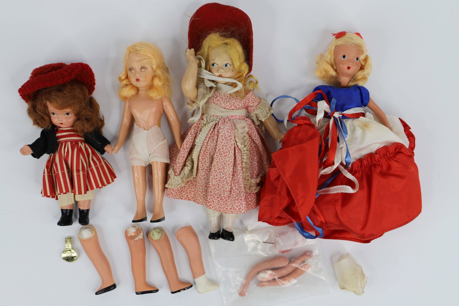 Nancy Ann Storybook Dolls: Three Nancy Ann dolls and one unmarked doll; "School Days" doll has all parts (plus extras), including gold label but needs to be restrung; Smallest is possibly "To Market"; Plastic Nancy Ann measures