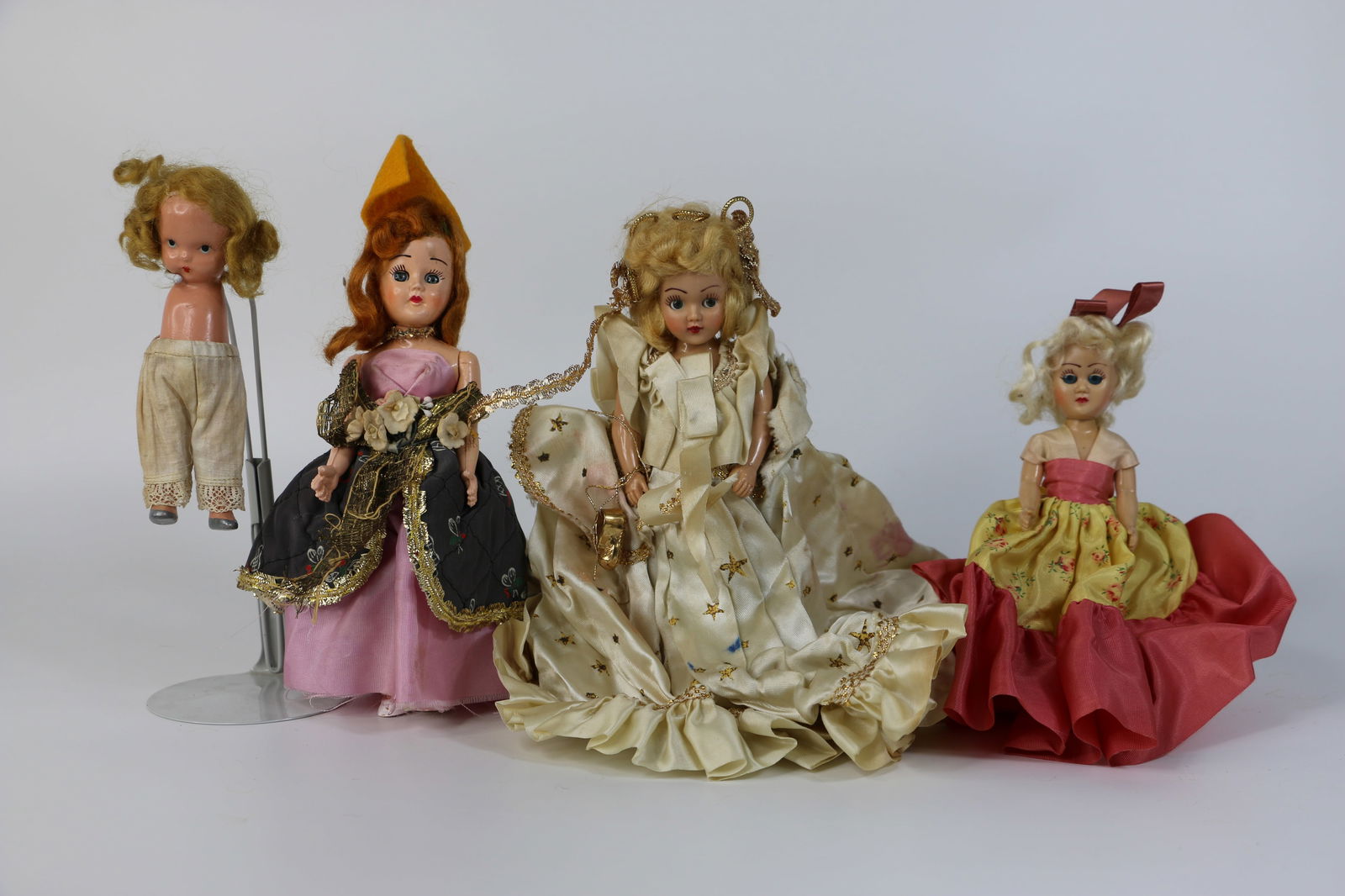 Vintage Dolls: One bisque Nancy Ann Storybook doll; Other three are unmarked plastic dolls; Two have open/close eyes; Tallest measures approximately H 7 1/4 inches; Bisque is missing arms and has unattached legs; St