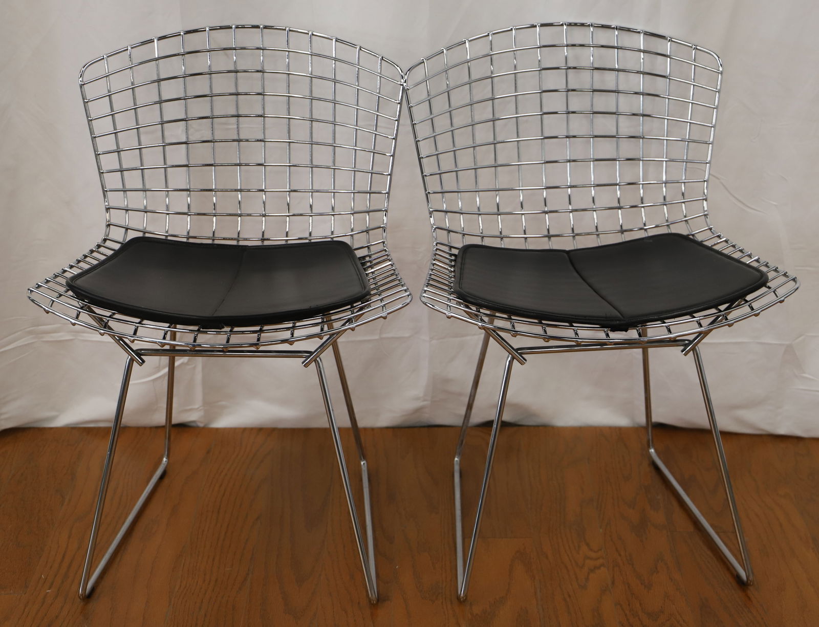 Knoll, Harry Bertoia, Side Chairs: Two vintage chrome side chairs by Knoll for Harry Bertoia; Leather seat pads; Measures approximately H 30 x W 21 x D 21 inches; Discoloration and rust present under the seat pad and in areas on the ba