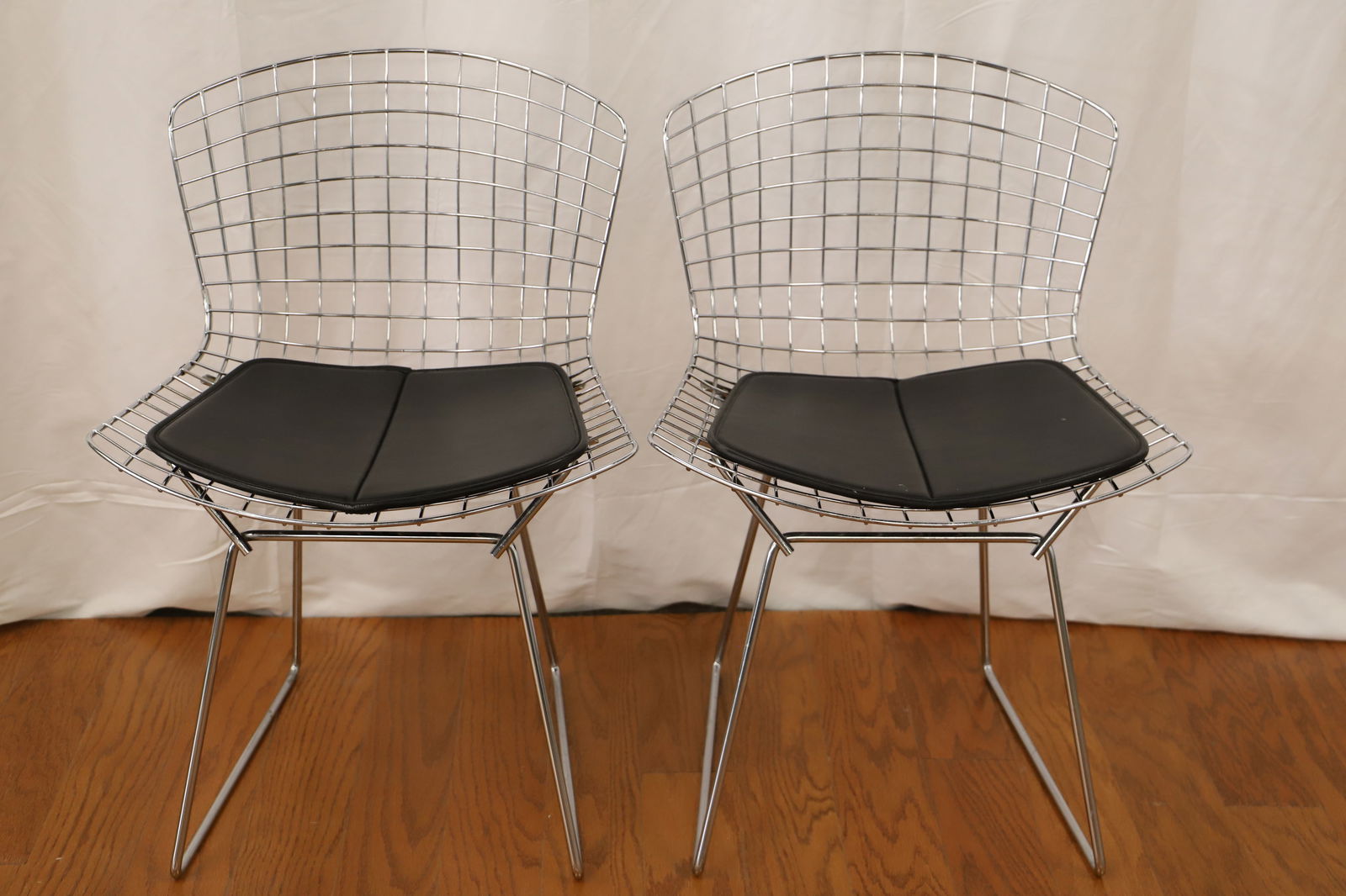 Knoll, Harry Bertoia, Side Chairs: Two vintage chrome side chairs by Knoll for Harry Bertoia; Leather seat pads; Measures approximately H 30 x W 21 x D 21 inches; Discoloration and rust present under the seat pad and in areas on the ba