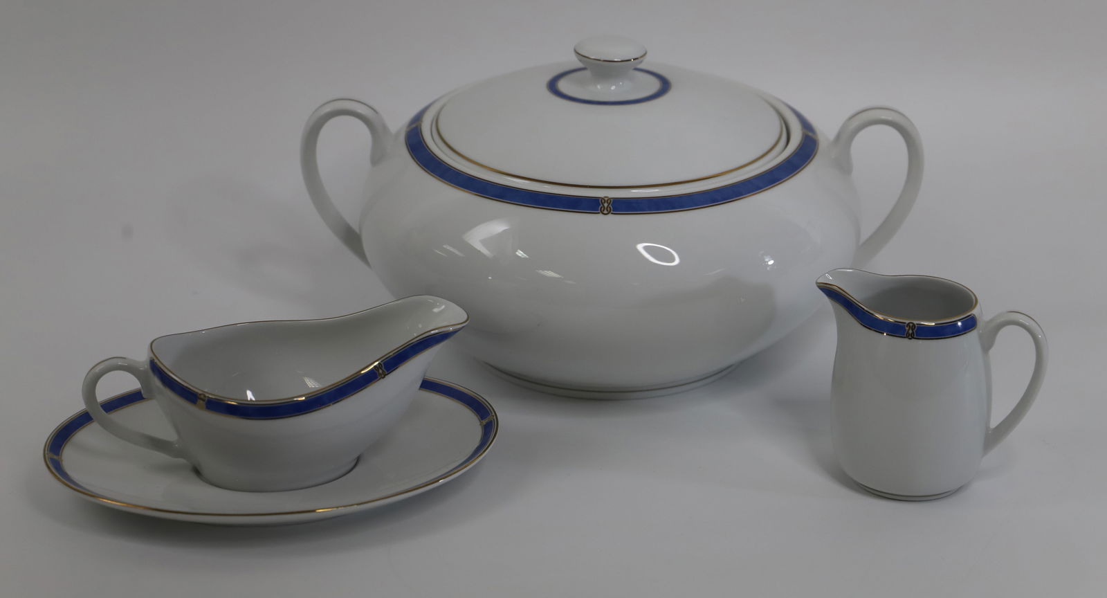 Christofle Porcelain, Serving Pieces: Gravy boat with underplate, creamer and covered casserole dish; All in the "Micro Gold" pattern; Casserole with lid measures approximately H 6 x W 13 x D 10 inches; No damage observed. See photos