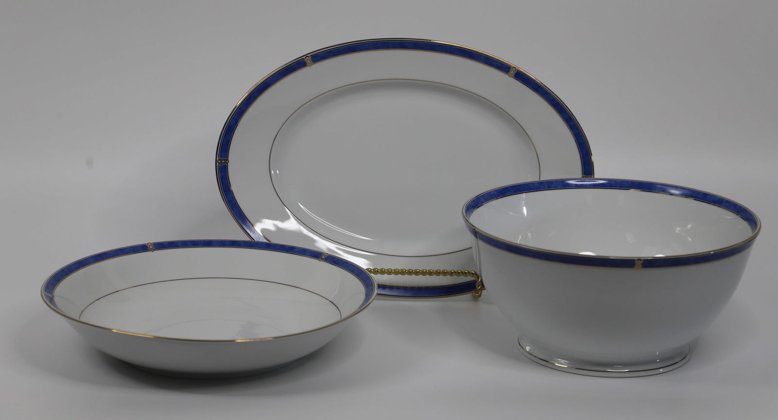 Christofle Porcelain, Serving Pieces: Oval platter and two round serving bowls; All in the "Micro Gold Oceana Bleu" pattern; Tallest bowl measures approximately H 4 3/4 x Diameter 10 inches; No damage observed. See photos