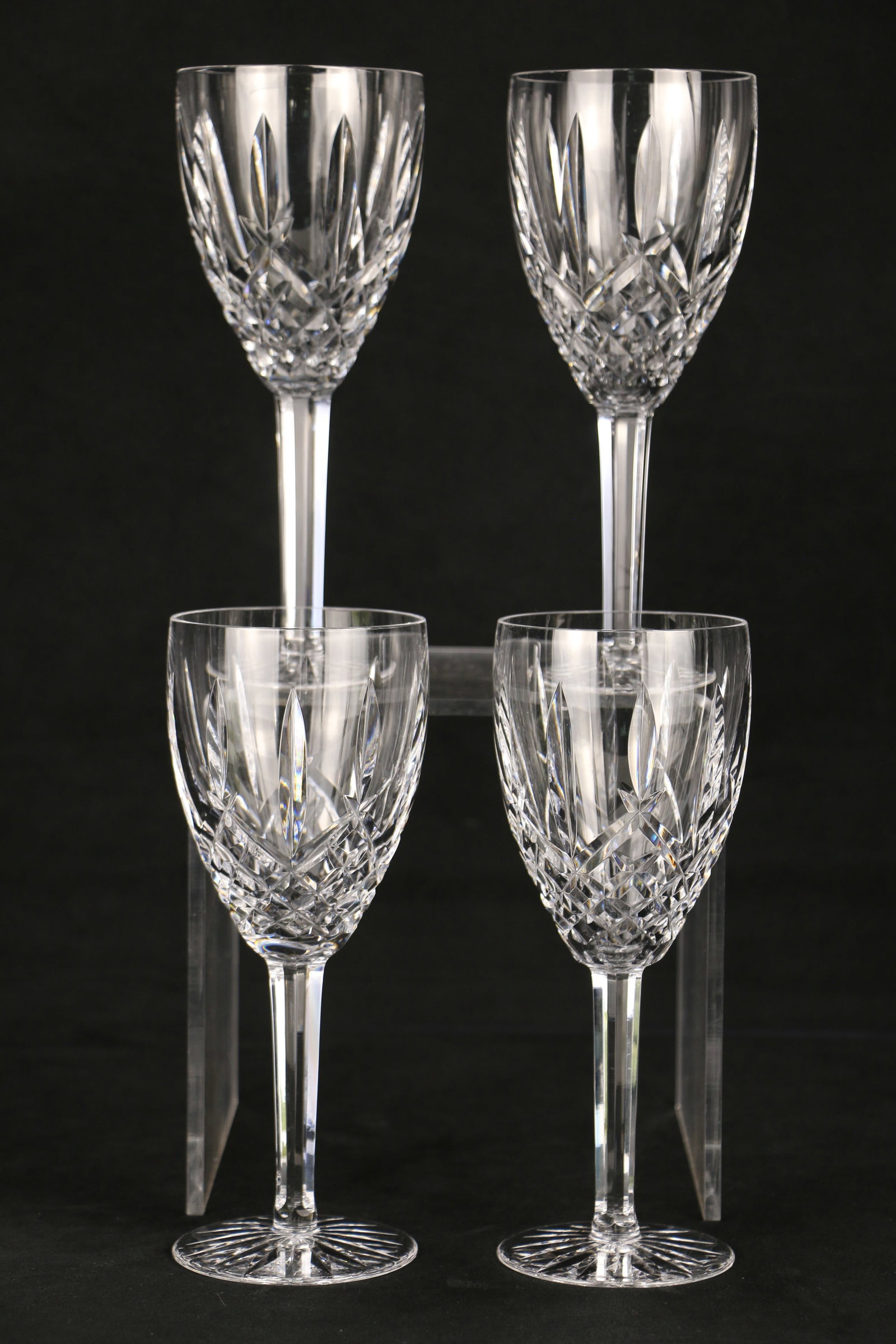 Waterford Crystal, Wine Glasses: Four wine glasses with the "Waterford" mark on the bases; Each glass measures approximately H 8 x Diameter 3 1/4 inches; One glass has a dark spec imbedded in glass stem. See photos