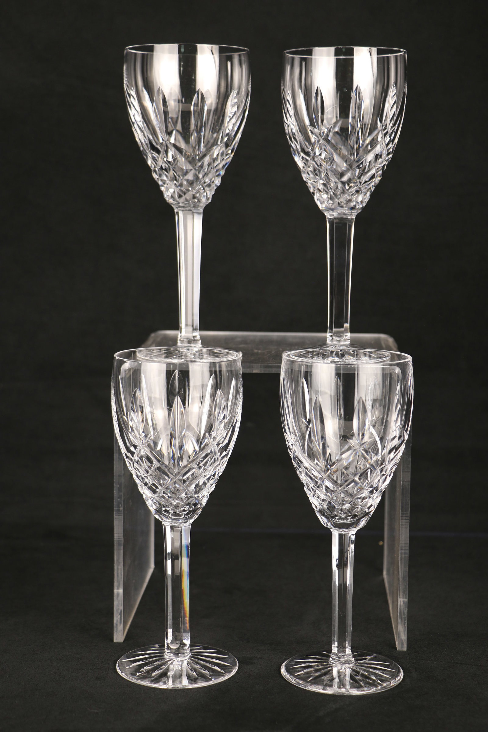 Waterford Crystal, Wine Glasses: Four wine glasses with the "Waterford" mark on the bases; Each glass measures approximately H 7 x Diameter 3 inches; One glass has a visible rim chip. See photos