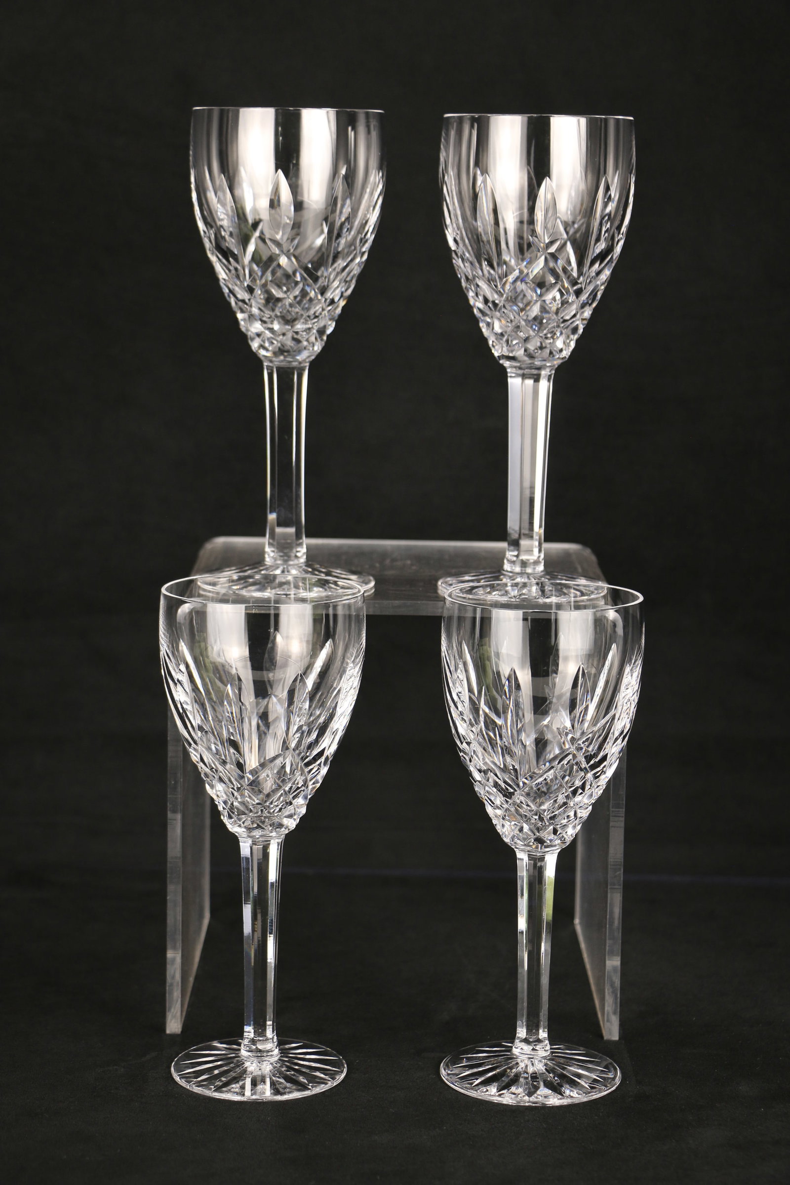 Waterford Crystal, Wine Glasses: Four wine glasses with the "Waterford" mark on the bases; Each glass measures approximately H 7 x Diameter 3 inches; One glass has a small rim chip. See photos