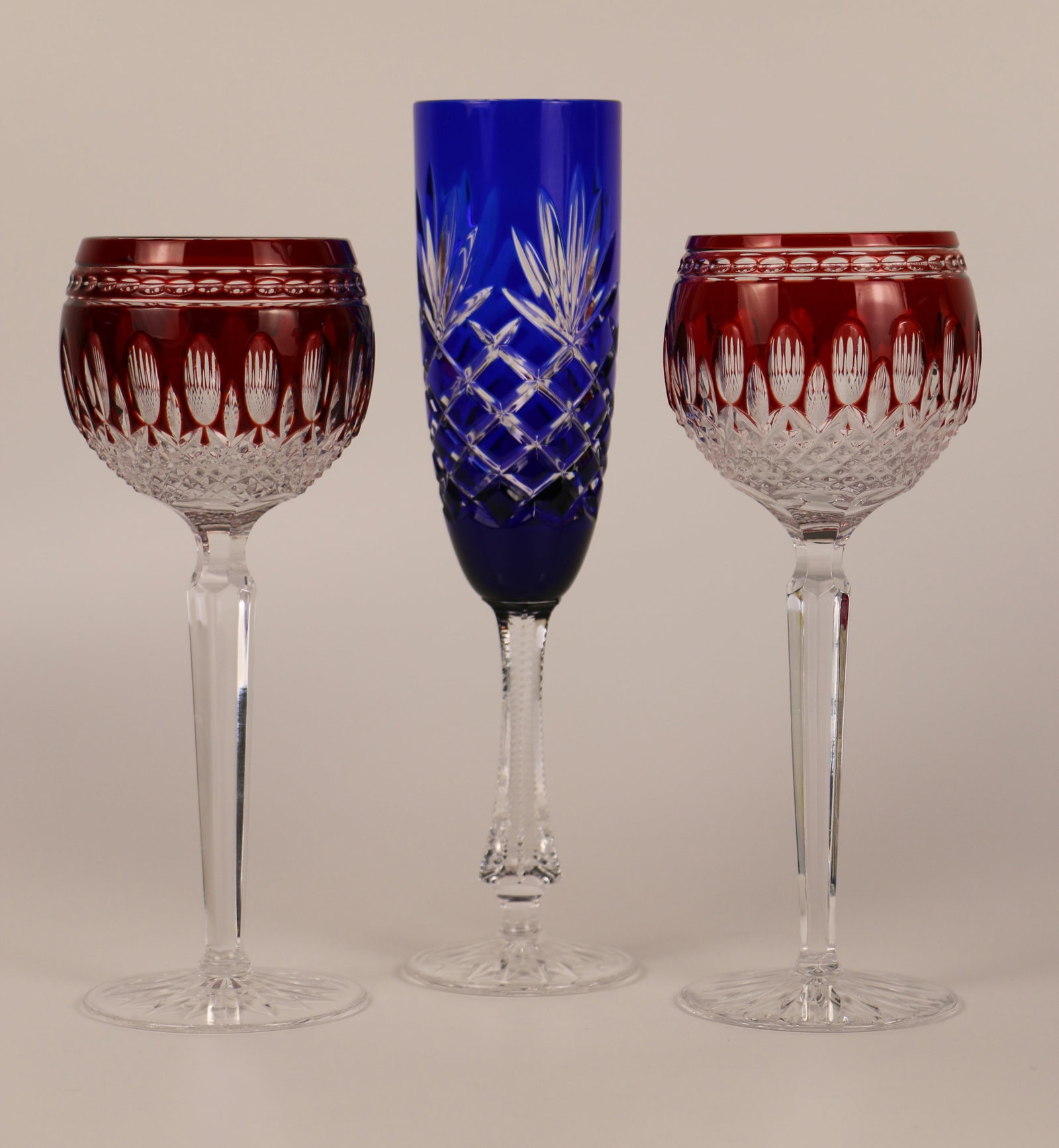 Waterford, Faberge, Wine Glasses: Two Waterford crystal, ruby, cut to clear wine glasses; One Faberge, cut to clear, cobalt champagne flute; All are marked on the bases; Wine glasses measure approximately H 8 x Diameter 2 3/4 inches; 