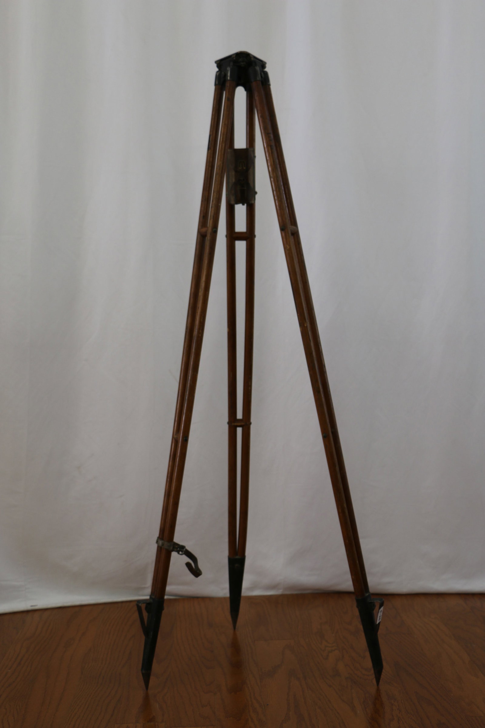 Surveyor Tripod: Vintage wood and metal tripod; Marked "Va 13097"; Attached leather pouch has a few accessories; An attached leather strap near the base keeps tripod securely folded; When closed is measures approximat