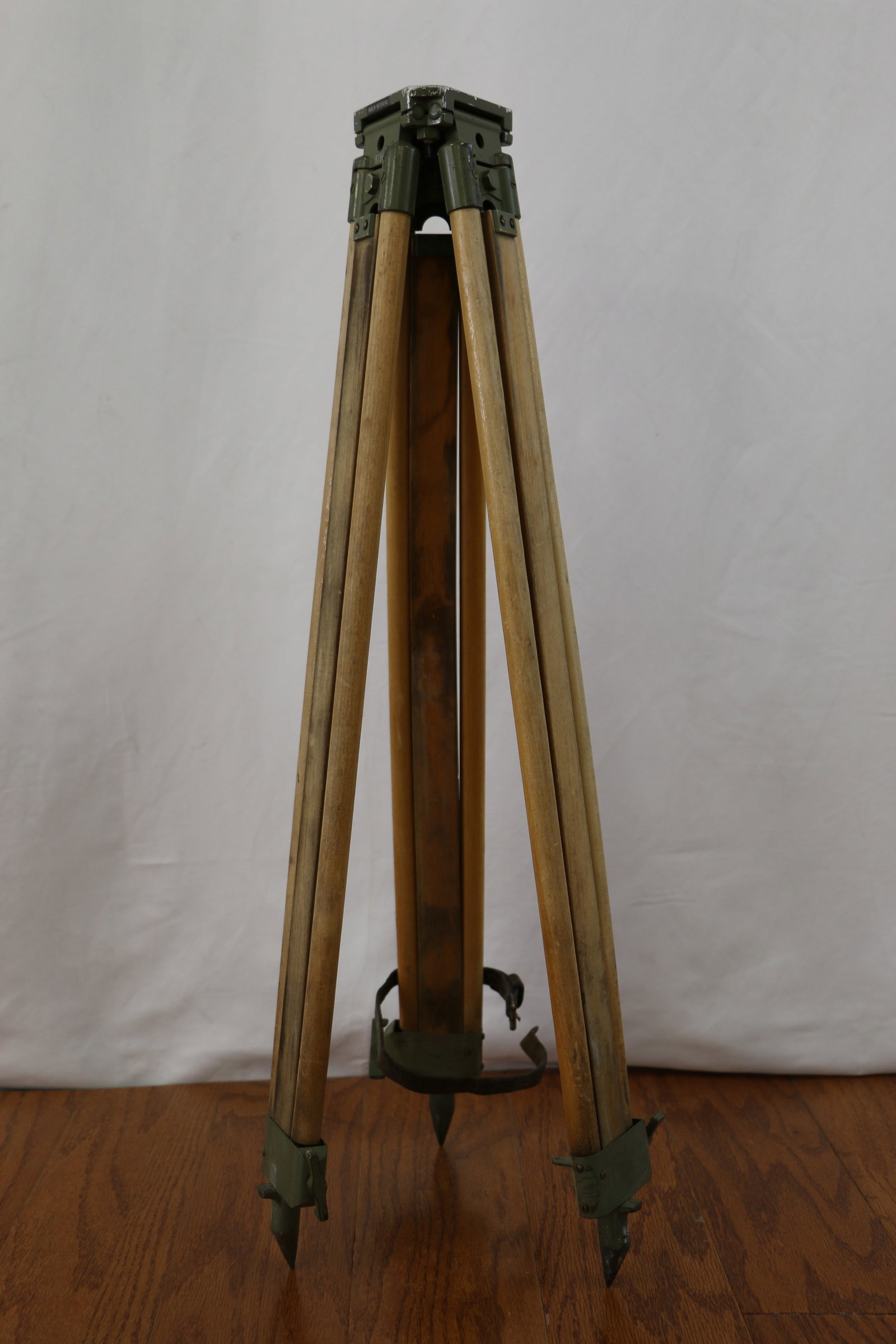 Surveyor Tripod: Vintage wood and metal expanding tripod; Marked "Made in Switzerland" and "1Xb"; Leather strap attached to wood to secure pieces when folded; When expanded it stands approximately H 45 inches; Folds u