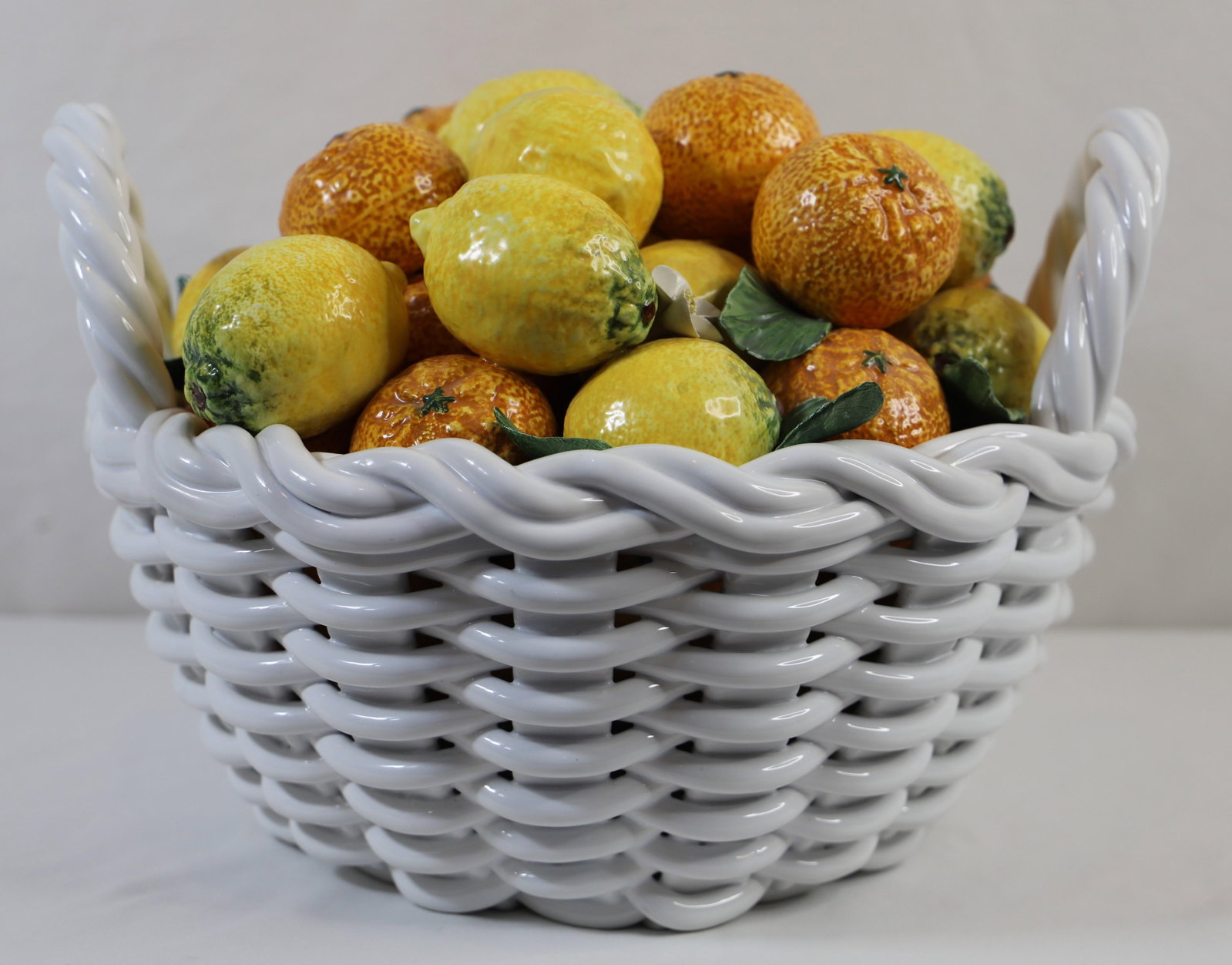 Porcelain Basket of Fruit: Large porcelain basket with attached porcelain fruit; Marked "Made in Italy"; Measures approximately H 9 x W 14 x D 15 inches; No damage observed; See photos. Pick up in Longmont