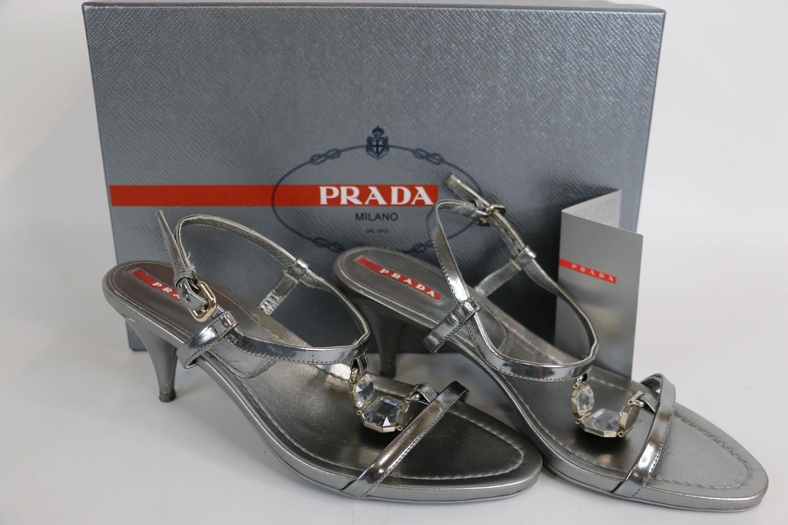 Prada, Ladies Sandals: Preowned women's Prada T-strap sandals with buckle closure; Size 37 (US 7 1/2); In original box; Slight wear on soles and heels. See photos