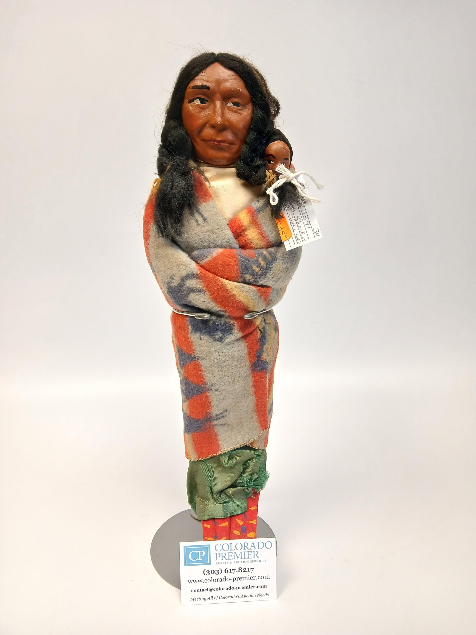 Antique Skookum with Papoose: One antique Skookum doll looking left with papoose wrapped in rare Indian print blanket; Doll has wooden feet; Tag on back of neck reads "Made in Occupied Japan"; Measures approximately 14 inches in h