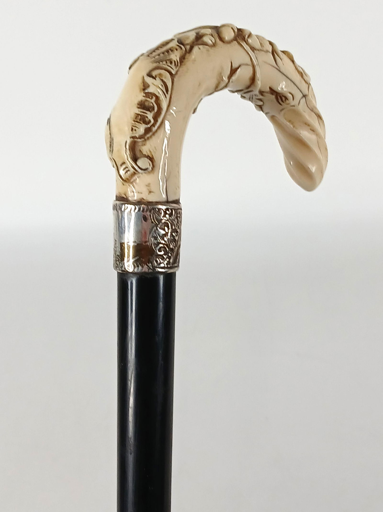 Carved Bone Cane: Victorian era cane (c) 1860-1900; Bone handle, silver toned collar, wood shaft, horn ferrule; No maker marks observed; Measures approximately H 38 inches; Scratches in the wood`. See photos