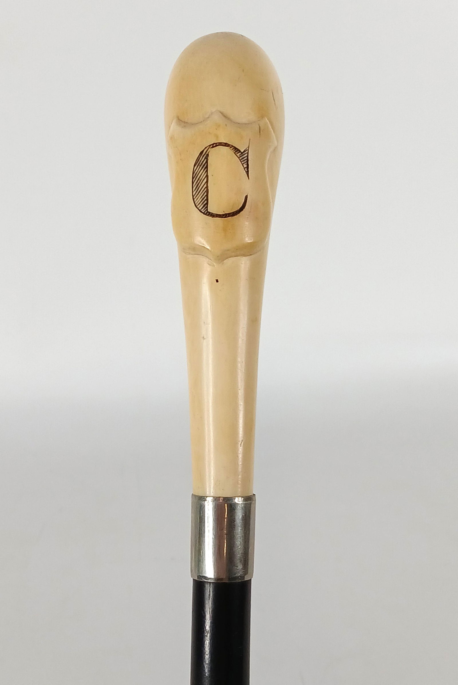 Monogrammed Bone Handle, Cane: Victorian era cane (c) 1860-1900; Bone handle with carved crest and the letter "C',silverplate collar, wood shaft, metal ferrule; No maker marks observed; Measures approximately H 34 1/2 inches; Wear