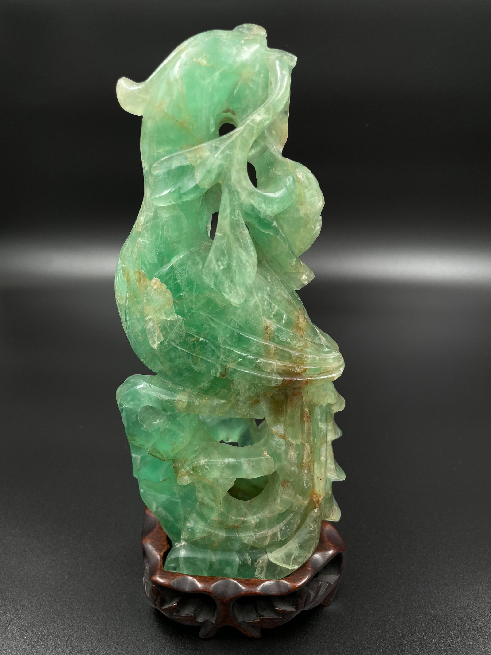 A Chinese rock crystal phenix carving.: Rock crystal, phenix carving with original hongmu stand. Dimension: Approximately H 10in (25cm) X W 2.75in (7cm)Provenance: From a local collector in Vancouver, BC.