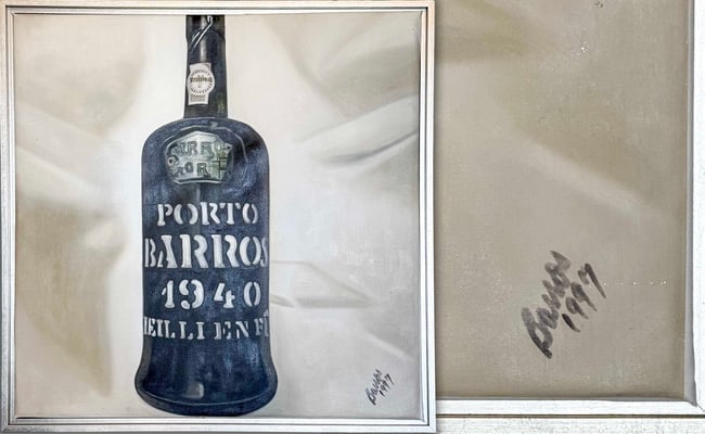 1940 Barros Colheita Port by Barros: A meticulously rendered original oil painting signed "Barros" lower right (with flourish) and dated "1997" on the verso/stretcher in black ink. This hyper-realistic still life centers on a single upri