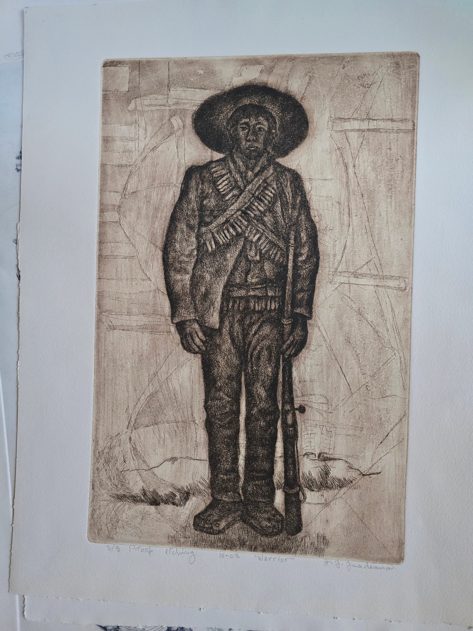 Warrior – Etching, 2003: An original etching by the renowned Texas artist José Guadiana, dated October 2003.This commanding portrait depicts a standing male figure in traditional wide-brimmed hat and bandoliers, holding a ri