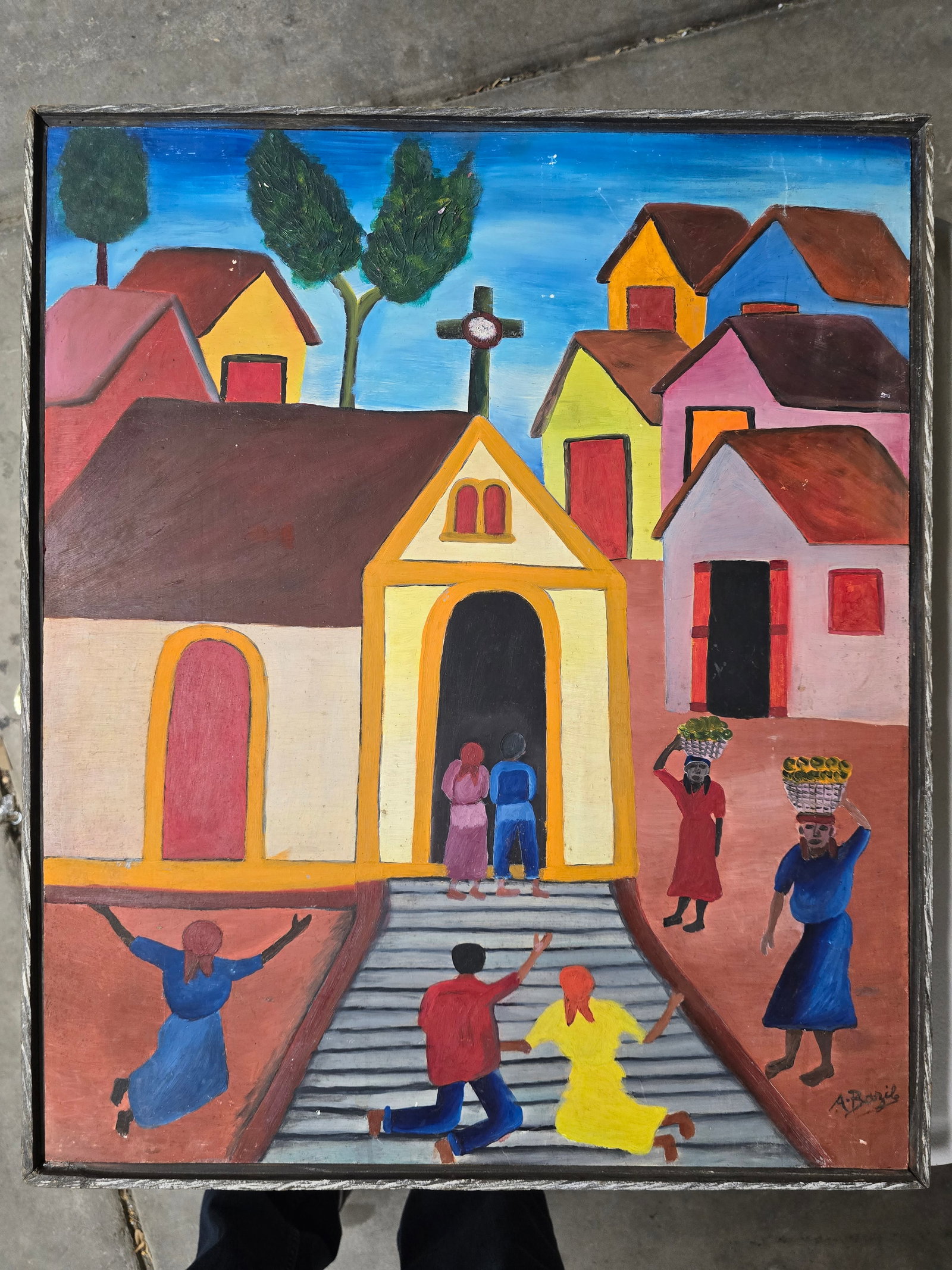 A. Bazile – Church Scene with Worshippers and Villagers, Bricston Collection: A vibrant and joyful Haitian naïve painting depicting a lively village church scene. A bright yellow church with a prominent cross stands at the center, its doors open as two figures enter. In the fo