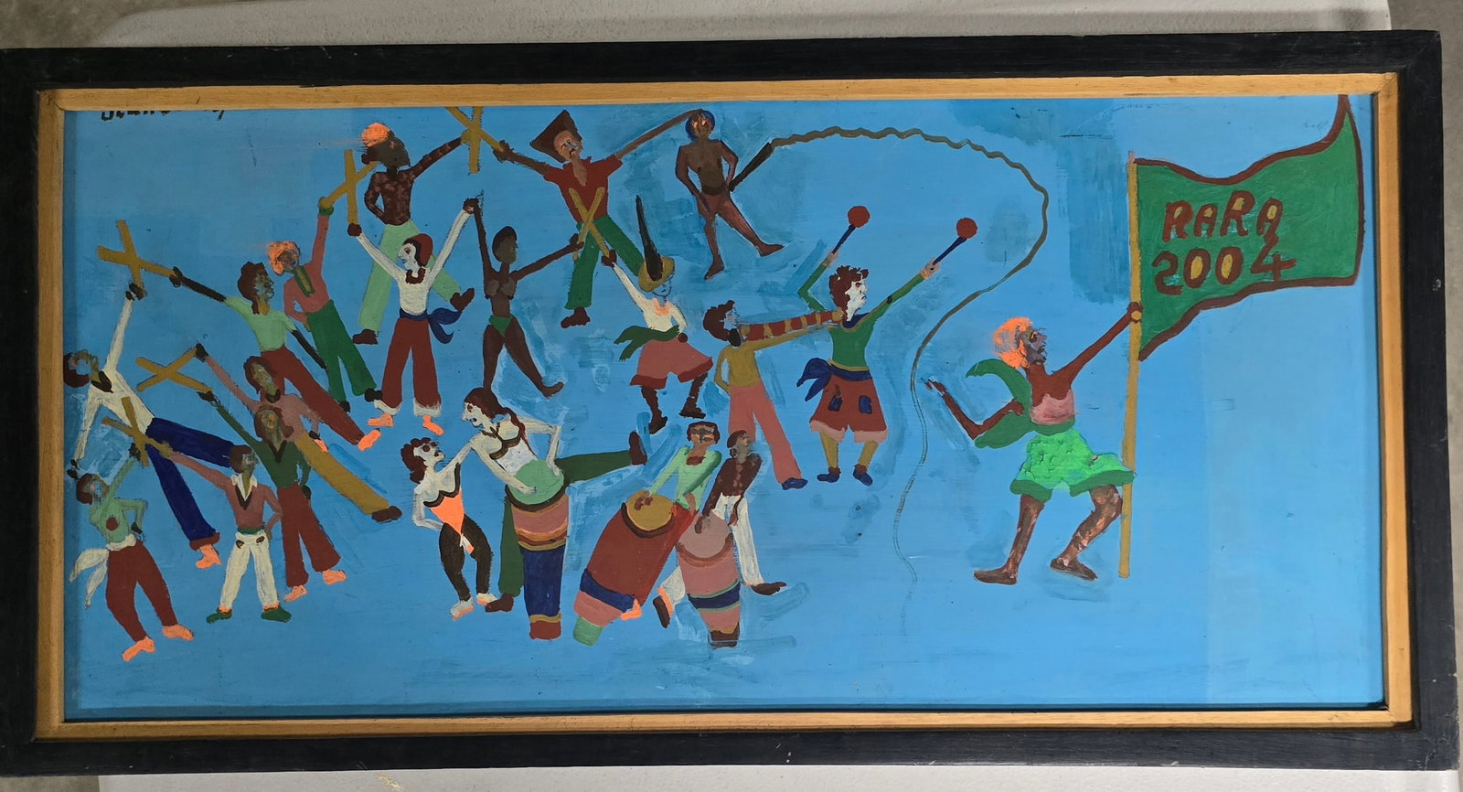 Rara 2004 Procession, Bricston Collection: A lively and energetic Haitian naïve painting capturing a vibrant Rara procession. A large group of figures dances dynamically across a bright blue background, many holding wooden crosses high in the
