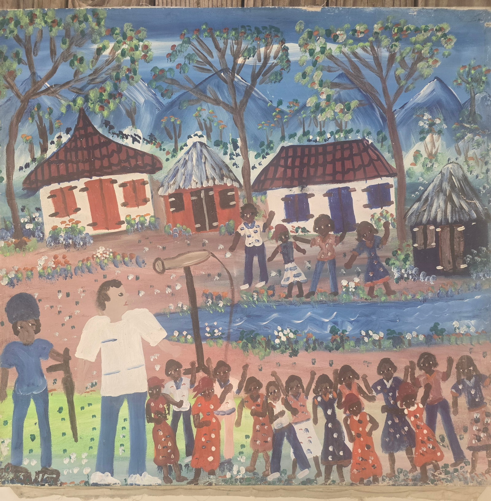 Haitian School (20th Century), Village Celebration with Children Dancing, Oil on Canvas, Framed, 28": This large, joyful Haitian naive painting captures a vibrant rural village celebration. In the foreground, groups of children dance and play around a central pole (possibly a maypole or speaker stand)