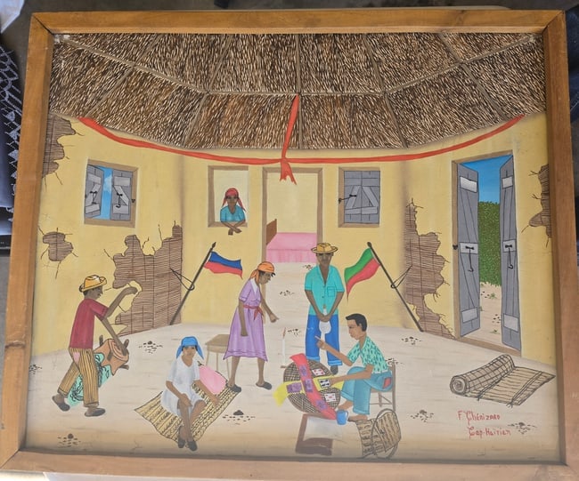 Haitian Fortune Teller F. Cherizaad: Vibrant and detailed original painting depicting a lively scene inside a large, circular thatched-roof house (typical of rural Haitian architecture). The interior shows cracked yellow walls, open door