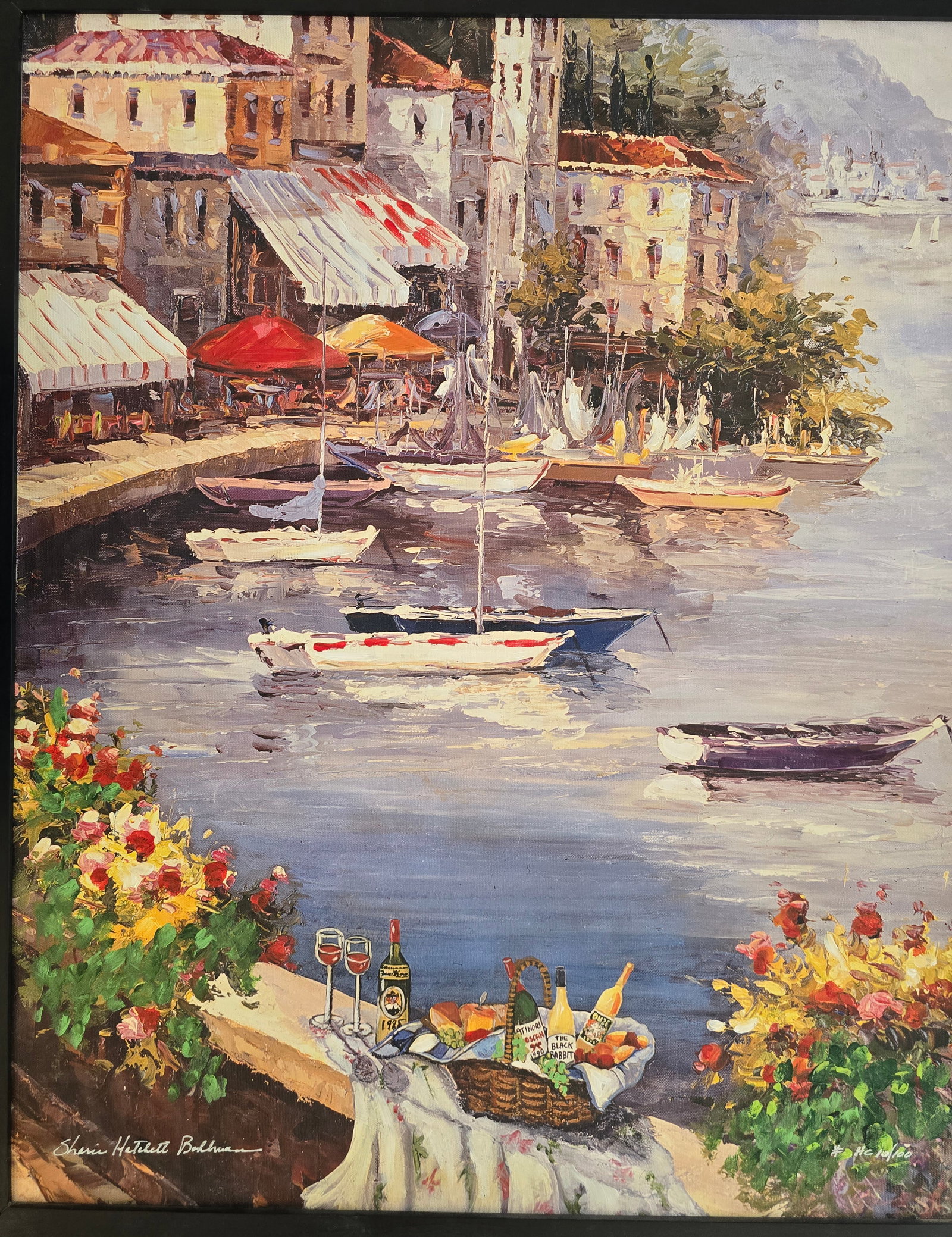 Harbor of Enchantment: A sunlit Mediterranean harbor town viewed from a flower-framed ledge set with a picnic spread, overlooking calm waters dotted with small boats and warm waterfront buildings before hazy mountains.