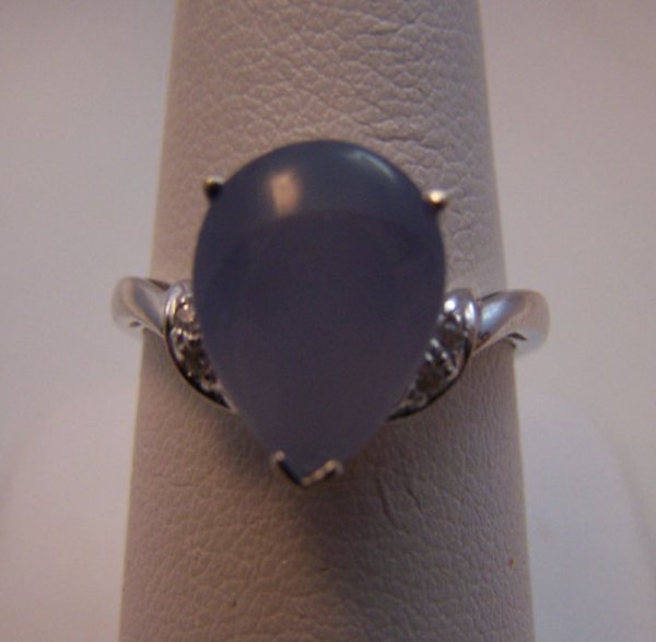 Ladies 14K white gold Moonstone Diamond Ring.: 69.) Ladies 14 Karat white gold Moonstone and Diamond fashion ring. The ring is composed of centered prong set Pear shape Moon stone measuring 12x9.25mm flanked by two round brilliant cut diamond on e