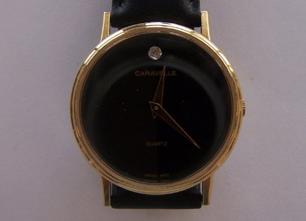 Gentleman's Carvelle Quartz Movement Watch.: Gentleman's Carvelle Quartz Movement Watch. Having a gray/black face with one diamond accent. Bulova watch ins stamped on the back. Black leather strap. [aww 0125]
