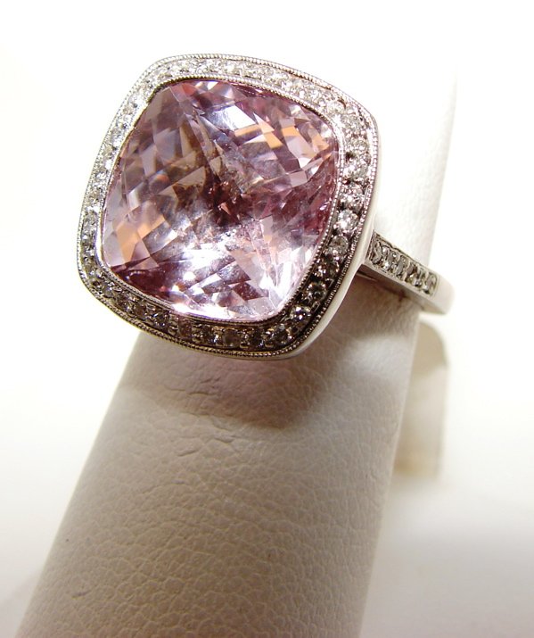 14K Kunzite Fashion Ring: AWR1811: 14 Karat White gold Kunzite and diamond fashion ring composed of centered cushion cut Kunzite outlined by micro pave set round brilliant cut diamonds weighing in total 0.50 carat. Ring weighs