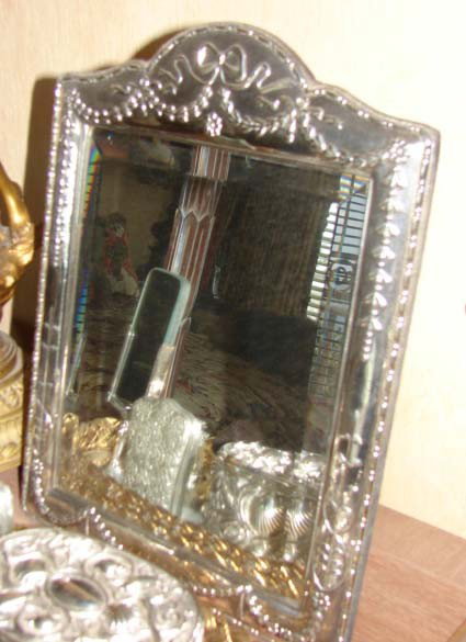 English sterling silver framed table mirror.: English sterling silver framed table mirror. H - 14.25" W - 10.5". Mirror having domed pediment with ribbon and bell flower garland, stop beaded rim, velvet easel back and bevel mirror inset. Bearing 