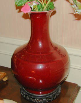 Chinese sang de boeuf style pottery vase.: H - 13", China, 20th C. reproduction. A good glazed vase in bottle form with carved teakwood fitted base.