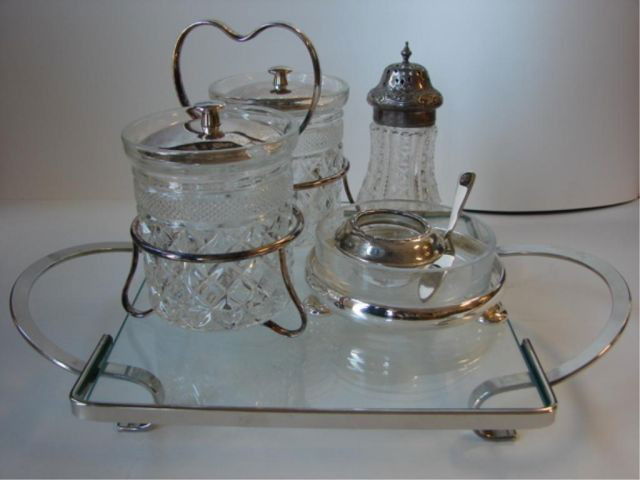 Group of four silver plate glass articles.: Including one sugar shaker, trivet, wine coaster, and jelly cruet set.