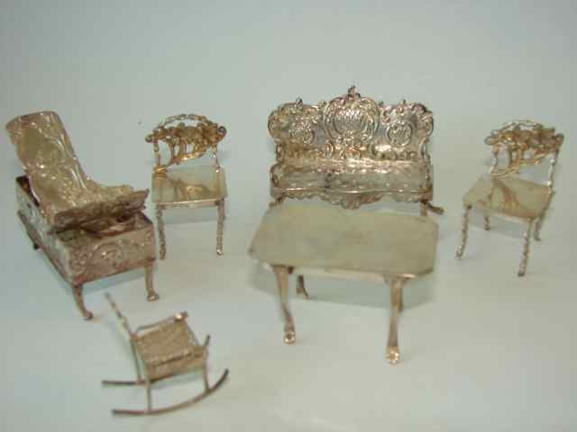 Six Assorted Silver Miniature Furniture Items.: 3.7 troy ounces total weight. Including a piano, settee, filigree rocking chair, and table and two side chairs.