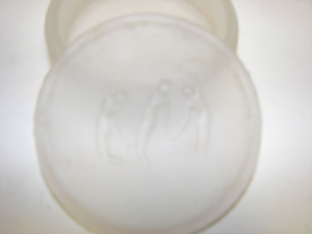 Lalique Glass Powder Box, Three Graces.: A frosted glass circular powder box and cover by R. Lalique , Trois figurines, French, circa 1935 moulded mark R. Lalique, 9.5cm diameter. Minor Chips.