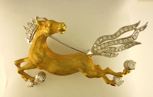 18K Yellow Gold Horse Form Pin.: 18 karat yellow and white gold running horse that measures 61 x 33 mm, with a hinged pin white gold back. The mane, tail and four hooves are in white gold and bead set with 44 round full cut diamonds.
