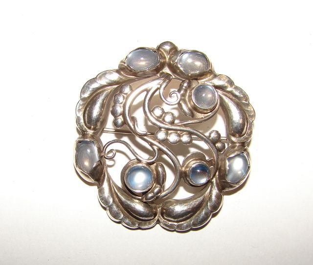 Georg Jensen Sterling Moonlite". Pin.": Set with 7 moonstones in cabochon cut. 17.5 grams total weight, 1 15/16 diameter."