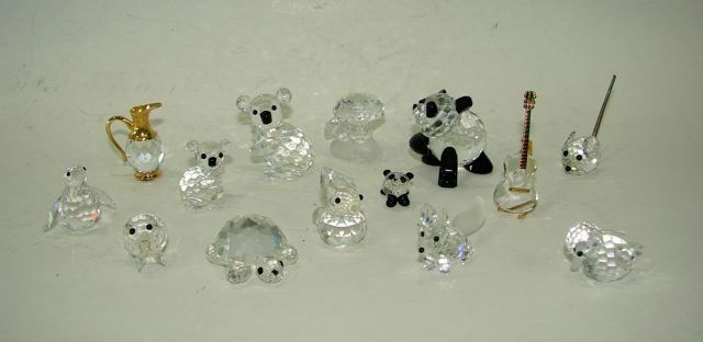 Group Fourteen (14) Swarovski Crystal Figurines.: Comprising Penguin, Bunny, Fox, Pig, Turtle, Duck, Mushroom, Guitar w/ stand, Mouse, Water pitcher, baby Panda with Mom, baby Koala with Mom. All With boxes.
