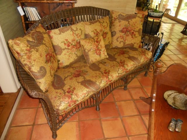 Rattan and Wicker Love Seat.: Length - 70", Heigh - 36", Upholstered chintz cushions, pillow backs.