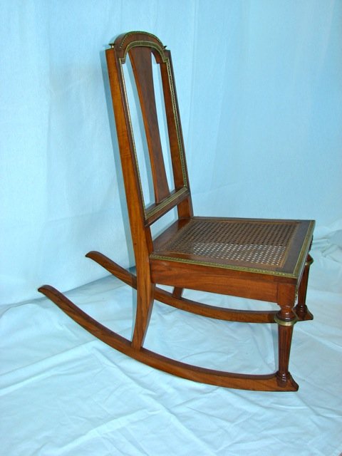 Louis XV Style Caned Rocker.: Height 36 in. Having a slat back and caned and seat, bronze mounted molding.