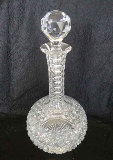 American Brilliant Cut Glass Decanter: With stopper. Unmarked, Russian cut pattern. Height - 11 inches. The decanter has a faceted stopper, with thumbprint neck, the base has 32 point star cut. [61]