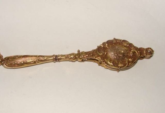 14K Yellow Gold Longurette: Having a fine repousse case with "C" scroll work, Mechanism spring opens to a pair of looking glasses, 34.6 grams total weight. Length - 5.5 inches. Condition: Unmarked but tested as 14 karat.