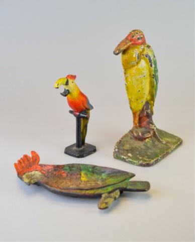 Metal Bird Grouping: 3 metal bird decorative items. Cast iron doorstop, 7 1/4"H; bronze tray, stamped 608 on underside, 7"L; cast iron bird on perch, 5 1/4"H. Paint loss to all.