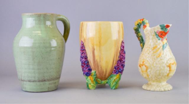 3 Pieces of Clarice Cliff Pottery: 3 pieces of Clarice Cliff pottery. Newport Pottery England Harvest pitcher, 9"H; Wilkinson Ltd. England green pottery pitcher, 9 1/4"; Newport Pottery England Bizarre by Clarice Cliff My Garden footed