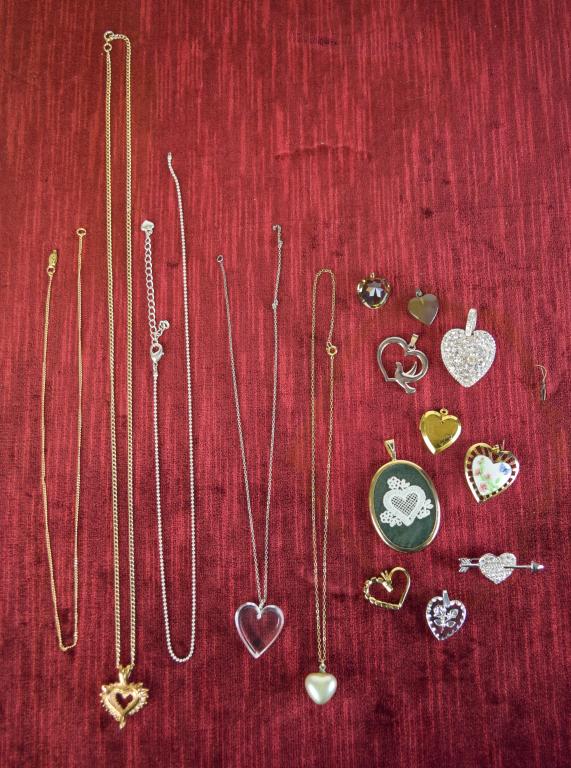 Costume Jewelry Heart Pendants: Lot includes gold tone and silver tone rhinestone heart pendants; faux pearl pendant; gold tone heart locket; rhinestone heart pin