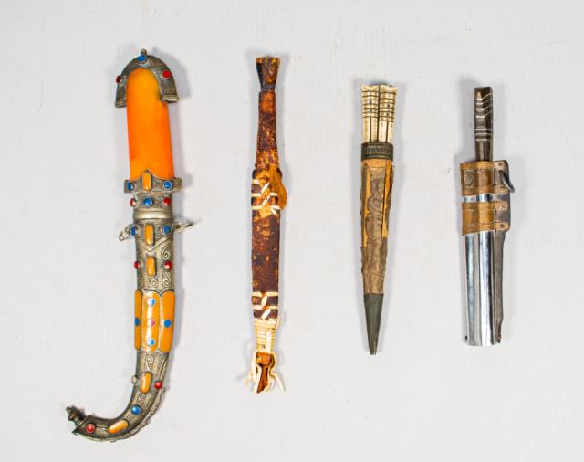 Lot of 4 Daggers: One Moroccan dagger, engraved metal and orange enamel and jeweled scabbard: 15 5/8" L One African Dagger, scabbard and hilt made of wood, hide and tissue: 12 3/4".One Asian Dagger, scabbard made of st