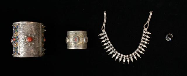 Grouping of Silver Tribal Jewelry: Lot includes large carved hinged silver cuff with carnelian and enamel embellishments, 4", 10 1/2" interior circumference, 335.6 grams with stones; carved silver cuff with glass embellishments, 2 1/4"