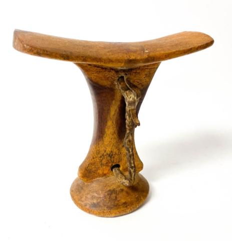 Turkana East African Headrest: Carved wood and hide handles. Scratches throughout and hide handles showing discoloration from age. 6 1/4" x 6" x 2 1/2" Provenance: From the Labelle Prussin Estate, Author of African Nomadic Architec