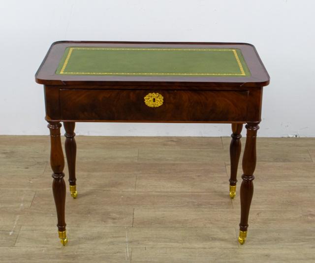 Mahogany Leather Writing Desk: A mahogany wheeled writing desk with green leather inlaid top. English, early 20th century. Cracks and scratches on top. 29" H x 33 1/2" L x 19" D